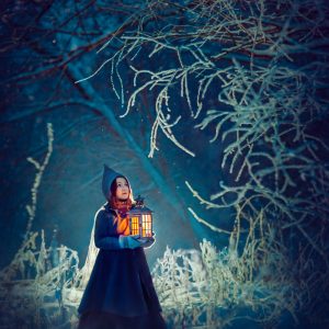 girl with lantern in a winter wood